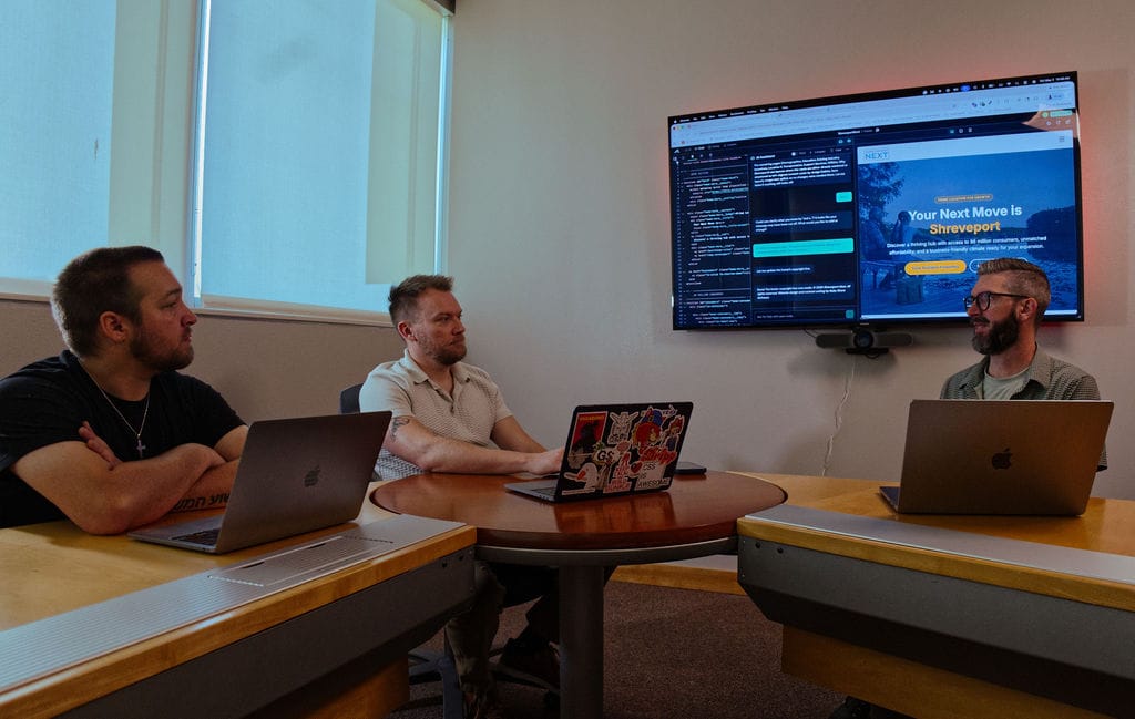 Ruby Shore team collaborating in a meeting room, reviewing a project on a large screen.