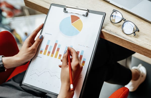 Person reviewing financial models on clipboard