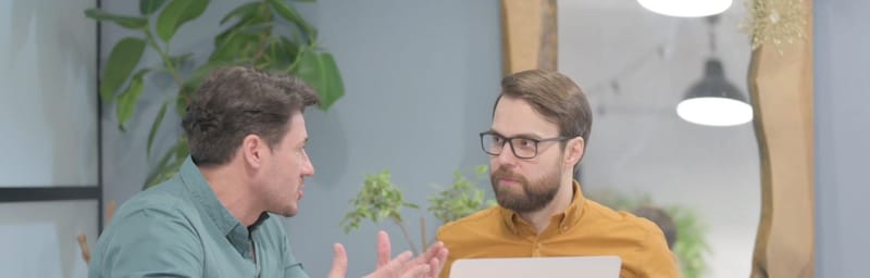 Two men sitting at a desk having a mentoring discussion